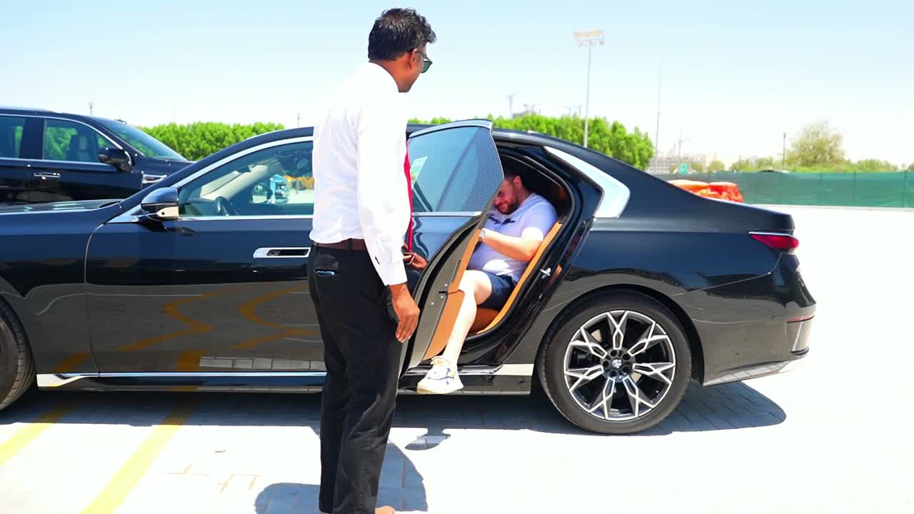 Red Carpet Dubai chauffeur helping a guest into a BMW 7 Series