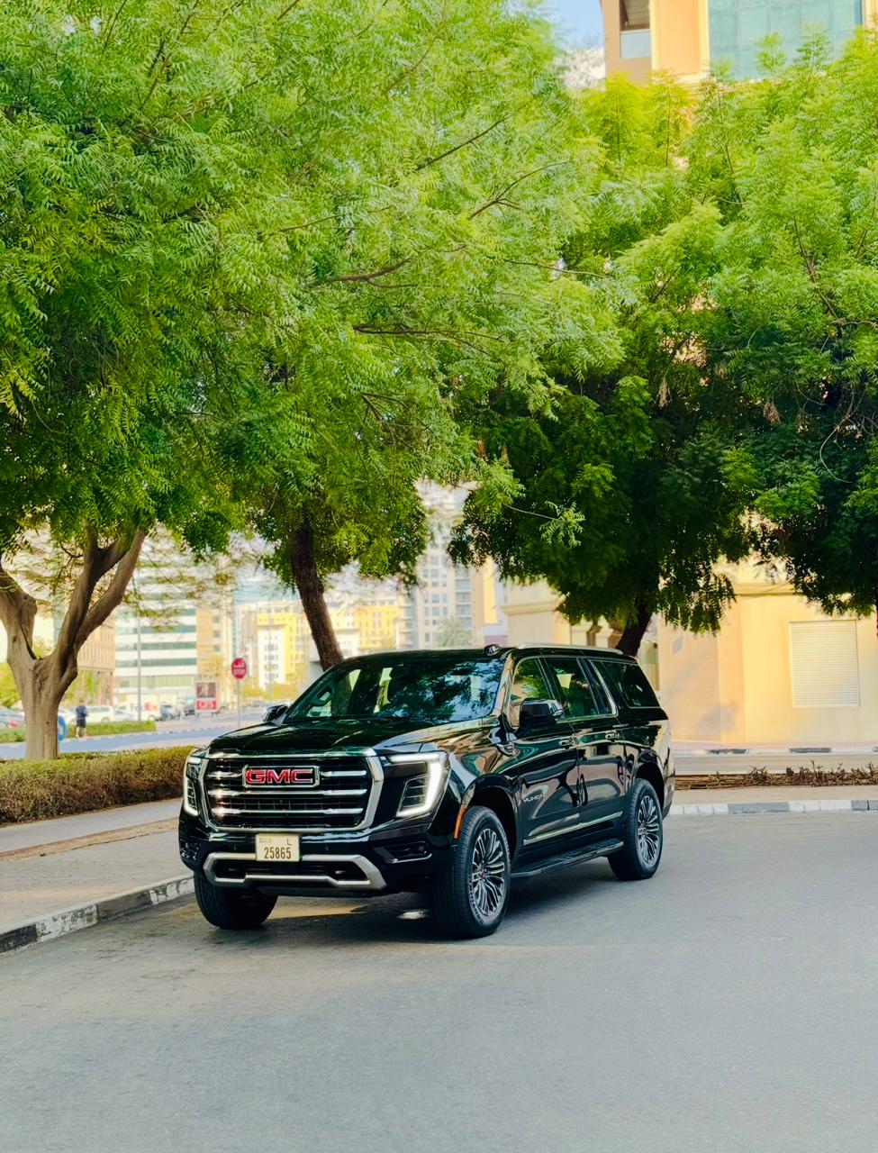 GMC Yukon XL — front view under trees