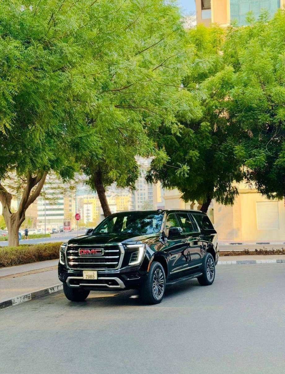 GMC Yukon XL — front view under trees